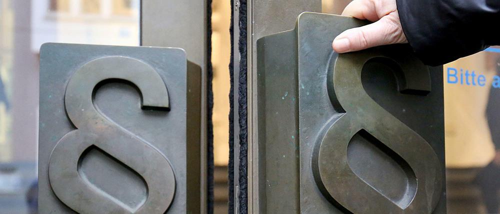 Paragrafen-Symbole sind an Türgriffen am Eingang zum Landgericht Bonn angebracht.