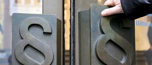 Paragrafen-Symbole sind an Türgriffen am Eingang zum Landgericht Bonn angebracht. 