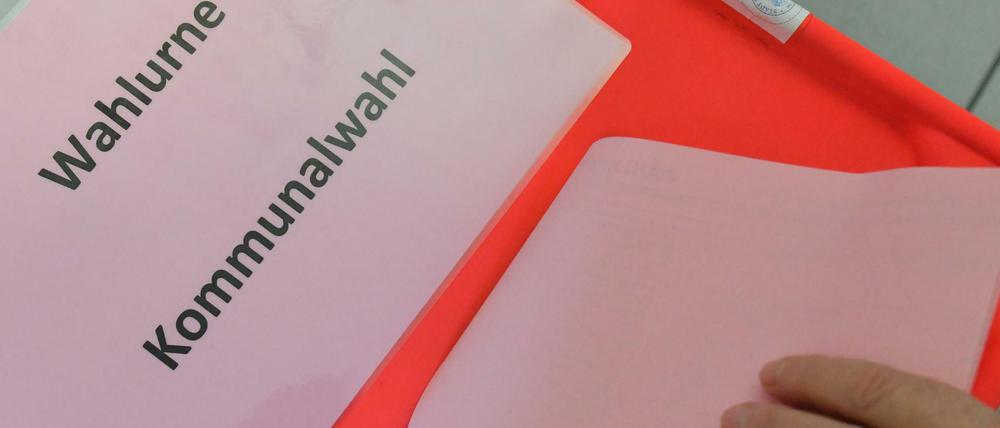 Eine Wählerin steckt ihren Stimmzettel zur Kommunalwahl in Brandenburg in die Wahlurne.