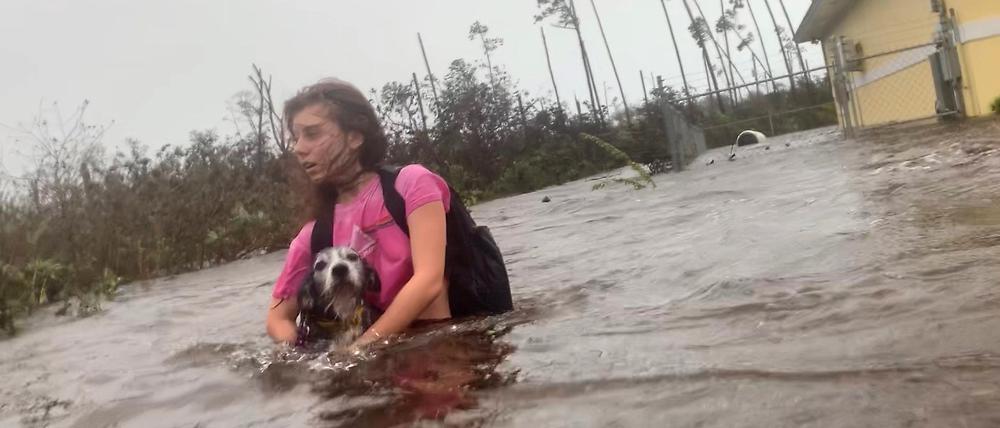 Bahamas, Freeport: Julia Aylen watet mit ihrem Hund durch hüfthohes Wasser auf einer überfluteten Straße. Sie ist die Tochter des Fotojournalisten Tim Aylen, dem Autor dieses Fotos.