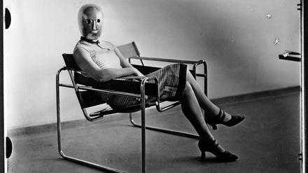 Wer blickt hier so stumm im Studio herum? Die Aufnahme einer Sitzenden mit Bühnenmaske von Oskar Schlemmer im Stahlrohrsessel von Marcel Breuer entstand um 1926. 