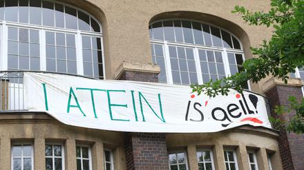 Auf einem Banner an der Fassade einer Berliner Schule steht "Latein is' geil".
