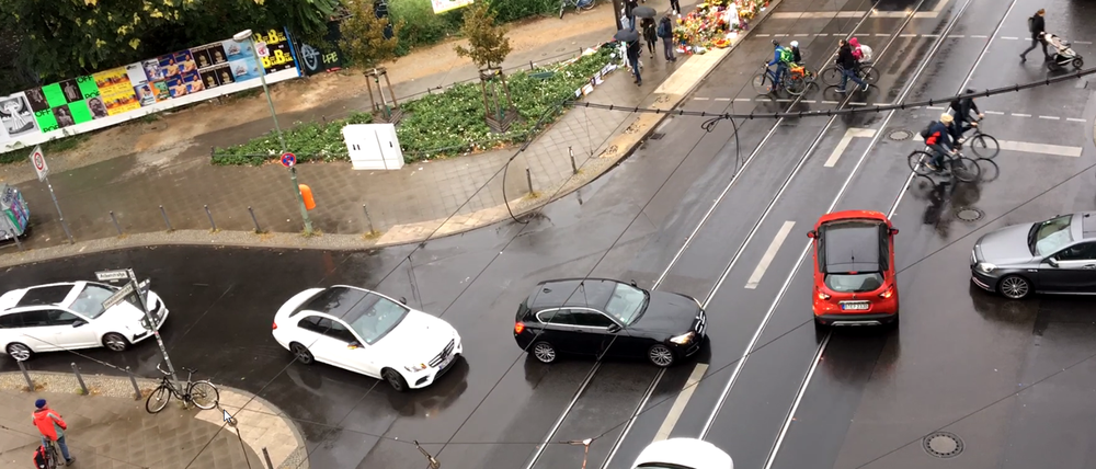 Am Montag nach dem Unfall ist die Ampel kaputt. Autos, Fahrradfahrer und Fußgänger konkurrieren um den Platz.
