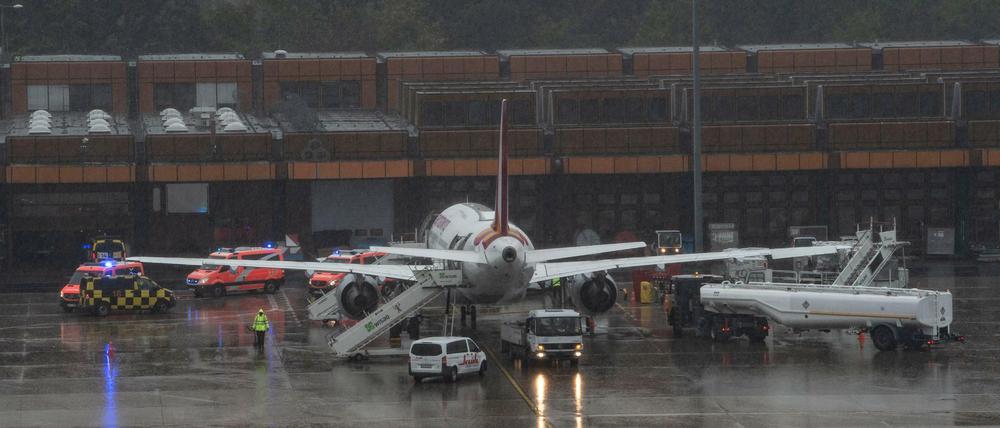 Einsatzfahrzeuge der Feuerwehr stehen um eine Maschine der Gesellschaft Eurowings am Berliner Flughafen Tegel.