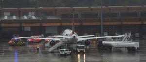 Einsatzfahrzeuge der Feuerwehr stehen um eine Maschine der Gesellschaft Eurowings am Berliner Flughafen Tegel. 