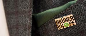 Gerd Müller (CSU), Bundesminister für wirtschaftliche Zusammenarbeit und Entwicklung, trägt während seiner Pressekonferenz einen Anstecker mit dem Symbol des staatlichen Textilsiegel "Grüner Knopf" am Revers.