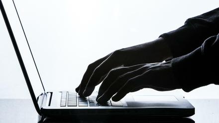 Ein Mann tippt auf einer Tastatur eines Laptops. (Symbolfoto) 