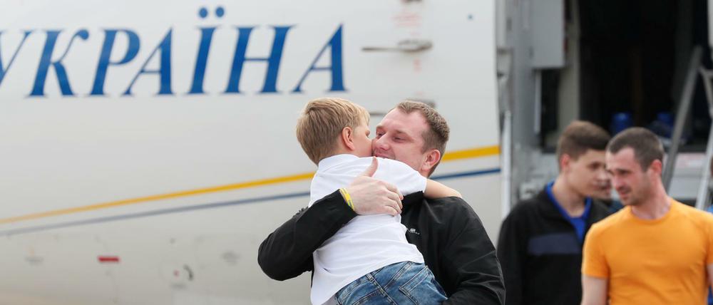 Einer der freigelassenen Ukrainer begrüßt ein Kind auf dem Flughafen in Kiew.