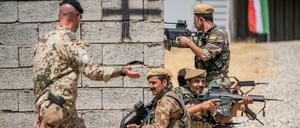Ein Bundeswehrsoldat (l.) bildet kurdischer Kämpfer im Nordirak aus.