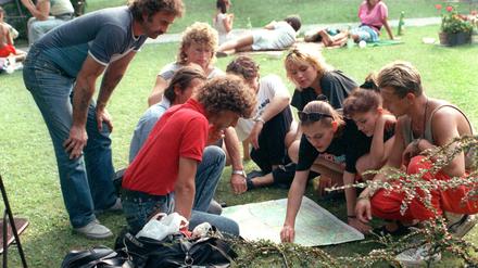 DDR-Bürger informieren sich am 17.08.1989 vor der deutschen Botschaft in Budapest auf einer Landkarte über den Verlauf der grünen Grenze.