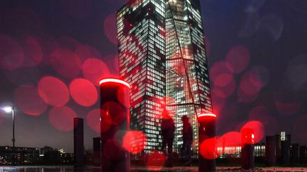 Die rote Beleuchtung von Sperrpollern an der Europäischen Zentralbank (EZB) und Regentropfen auf dem Kameraobjektiv erzeugen am kreisförmige Reflexionen