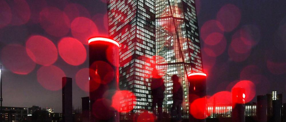 Die rote Beleuchtung von Sperrpollern an der Europäischen Zentralbank (EZB) und Regentropfen auf dem Kameraobjektiv erzeugen am kreisförmige Reflexionen