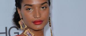 Indya Moore mit den Ohringen, die Bilder von getöteten trans Frauen zeigen.