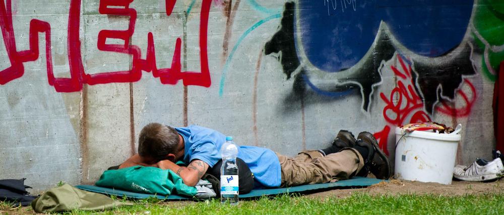 Ein Obdachloser schläft nahe dem Bahnhof Zoo.