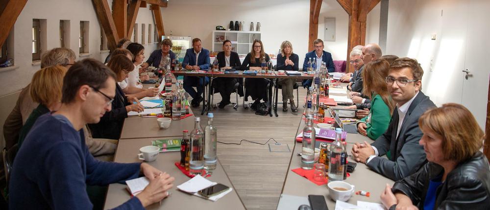 Vertreter der Partei Bündnis 90/Die Grünen (links), die Linke (hinten) und der SPD (rechts) sitzen vor Beginn der Sondierungsgespräche über eine mögliche Koalition im Sitzungsraum.