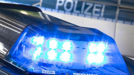Ein Blaulicht leuchtet am auf dem Dach eines Polizeiwagens. 