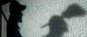 Der Schatten eines Malers ist auf einer Hauswand. Gewerkschaften wollen einen besseren Schutz der Arbeiter.