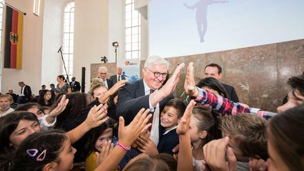 Frank-Walter Steinmeier klatscht Schüler ab, die ihm die Hände entgegenstrecken.