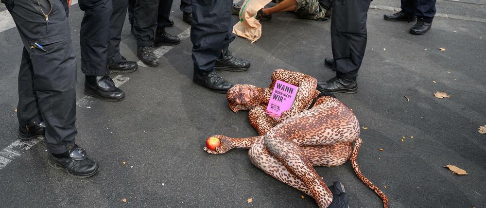 Radikal und kreativ: eine Klimaaktivistin von "Extinction Rebellion" liegt bei einer Blockade der Warschauer Straße.