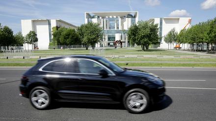 Ein Porsche Macan fährt am Bundeskanzleramt vorbei. 