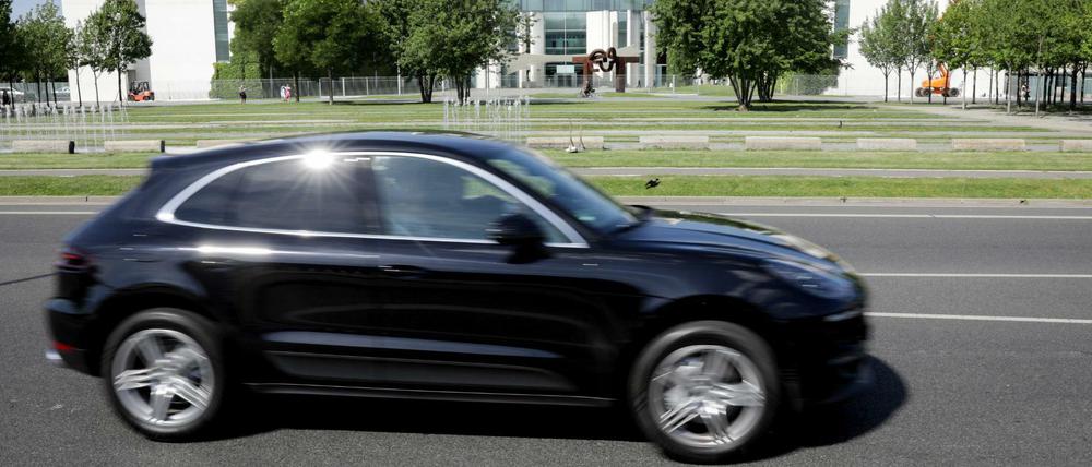 Ein Porsche Macan fährt am Bundeskanzleramt vorbei. 