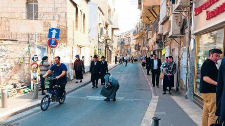 Kunst im Konflikt. Ein verärgerter orthodoxer Jude macht die von Addam Yekutieli auf die Hauptstraße des Viertels Mea Shearim gesprayte Schrift unleserlich.
