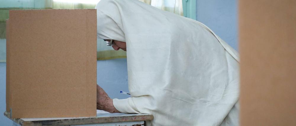 Eine Tunesierin füllt ihren Stimmzettel in der Wahlkabine aus. Rund sieben Millionen Tunesier sind an diesem Sonntag aufgerufen, einen neuen Präsidenten zu wählen.