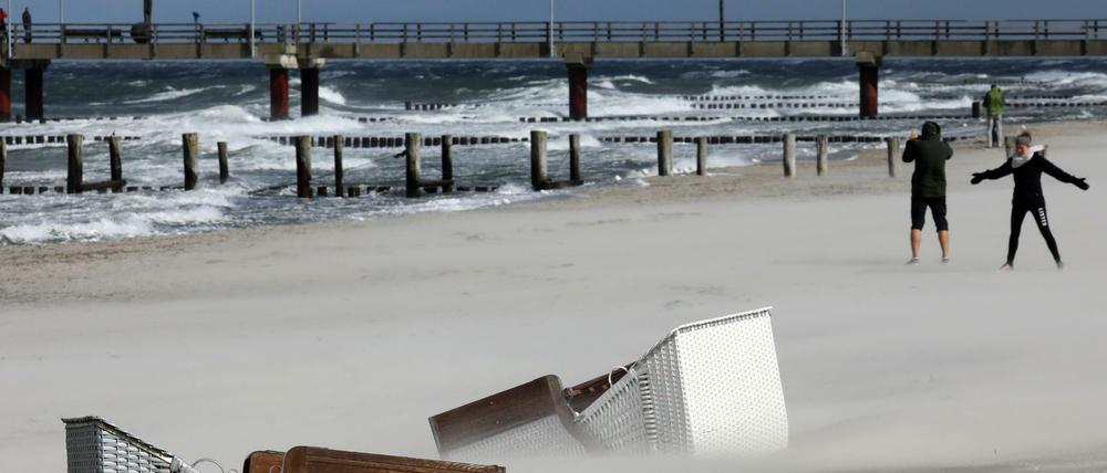 Am Strand von Zingst liegen umgefallene Strandkörbe im Sand.