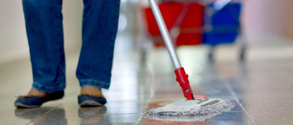 Eine Gebäudereinigerin wischt einen Flur in einer Berufsschule in Schwerin. Aus Sicht von Gewerkschaften sowie Frauen- und Sozialverbänden sind Minijobs eine "Niedriglohnfalle".