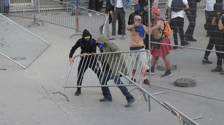 Vermummte brechen eine Barrikade bei dem Klimaprotest in Paris.