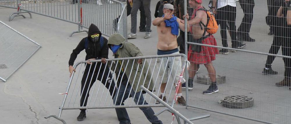 Vermummte brechen eine Barrikade bei dem Klimaprotest in Paris.