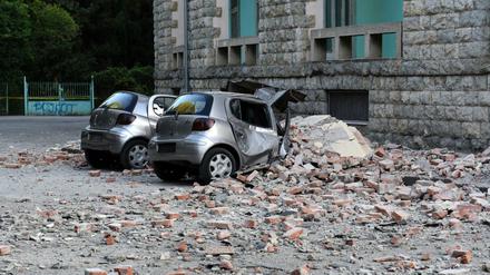 Zwei beschädigte Autos liegen nach einem Erdbeben vor dem Gebäude der Geologie-Fakultät in Tirana.