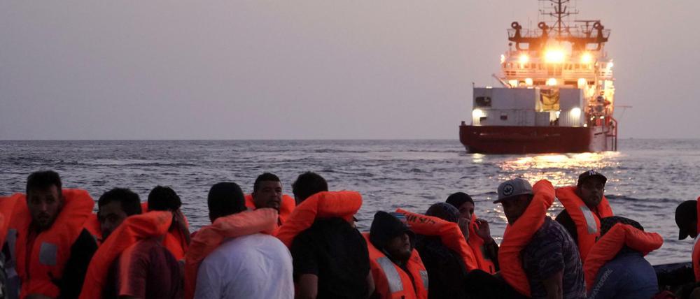 Migranten auf einem überfüllten Holzboot warten auf die Rettung durch die Ocean Viking.