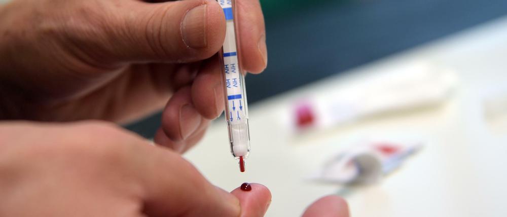 Ein junger Mann führt einen HIV-Selbsttest durch.
