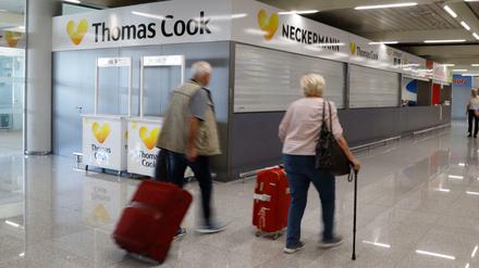 Passagiere gehen an einem geschlossenen Thomas-Cook-Schalter auf Mallorca vorbei.