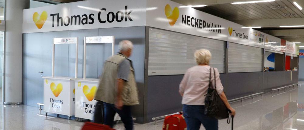 Passagiere gehen an einem geschlossenen Thomas-Cook-Schalter auf Mallorca vorbei.