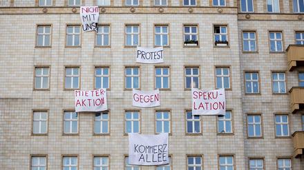 Plakate gegen den Verkauf von Mietwohnungen an einer Gebäudefassade in der Karl-Marx-Allee.