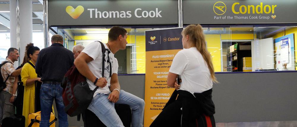 Passagiere warten neben dem Büro von Condor und Thomas Cook auf Mallorca.
