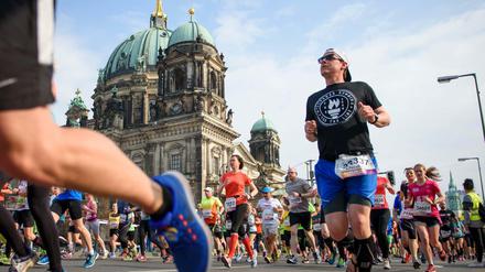 Teilnehmer laufen während des 37. Halbmarathon in Berlin am Berliner Dom vorbei.