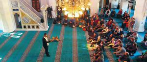 Am Tag der offenen Moscheen 2015 in der Berliner Sehitlik-Moschee spricht ein Vertreter der Moschee mit Besuchern.