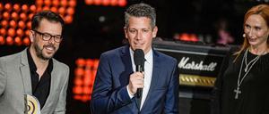 Schauspielerin Andrea Sawatzki, Schauspielerin steht als Laudatorin während der Verleihung des 10. Deutschen Radiopreises auf der Bühne neben Marc Haberland und Vivian Pickelmann (links) von 104.6 RTL, die den Preis in der Kategorie "Beste Innovation" gewonnen haben.