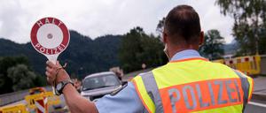 Polizisten kontrollieren an einer mobilen Kontrollstelle kurz hinter der Grenze zu Österreich Fahrzeuge. 