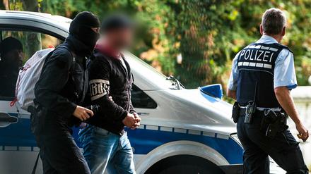 Einer der mutmaßlichen Rechtsterroristen wird abgeführt.