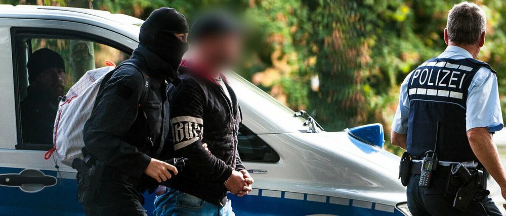 Einer der mutmaßlichen Rechtsterroristen wird abgeführt.