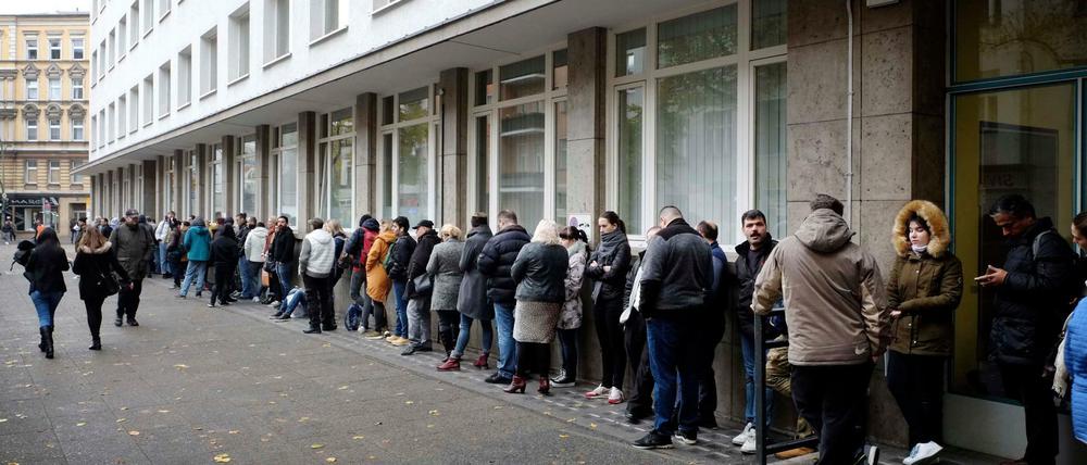Menschen warten vor dem Eingang zum Bürgeramt am Rathaus Neukölln.
