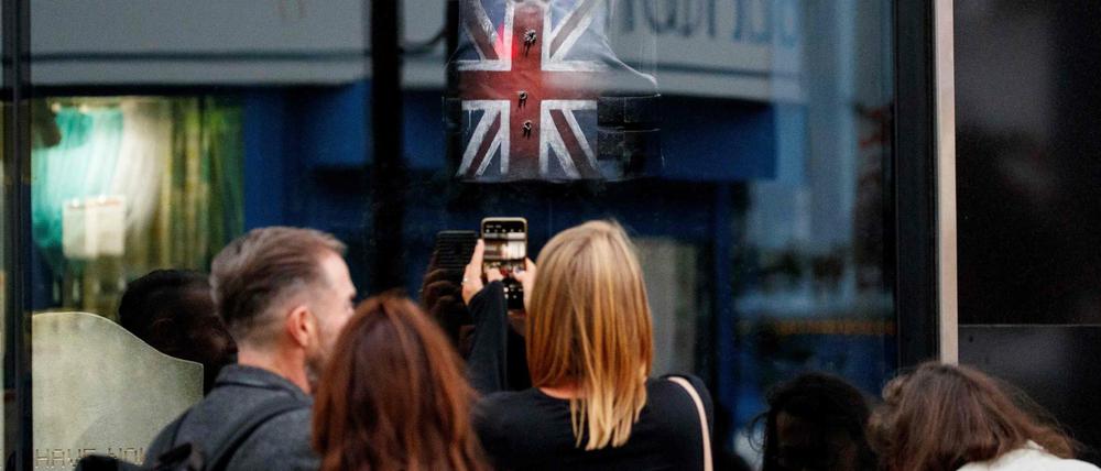 Londoner Passanten versammeln sich vor dem Schaufenster des Banksy-Shops, in dem auch die berühmte Stormzy-Weste ausgestellt ist.