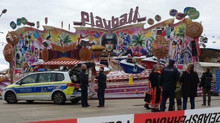 Polizisten und ein Polizeiwagen stehen vor dem Fahrgeschäft „Playball“