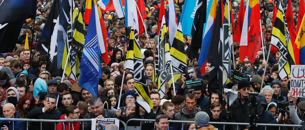 Demonstranten halten Flaggen und Banner während einer Kundgebung für die Freilassung politischer Gefangener hoch. 