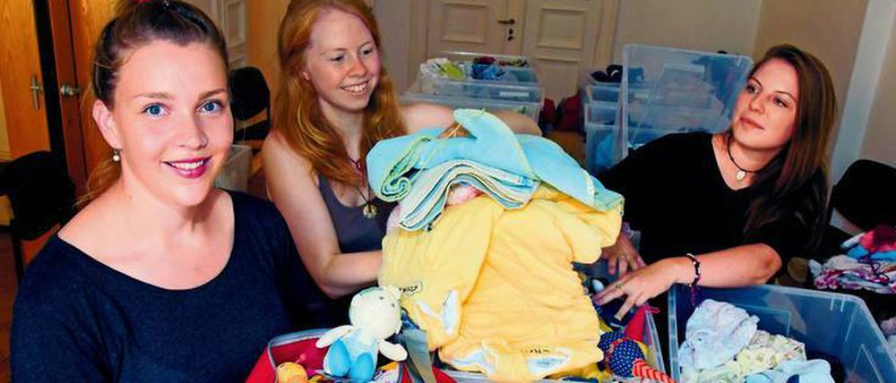 Projektleiterin Amelie Schwermer, Pia Meier und Mia Linthe (von links) beim packen der Babybags.