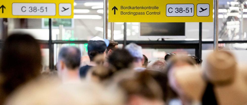 Passagiere stehen am Flughafen Tegel im Terminal C vor der Sicherheitskontrolle Schlange.